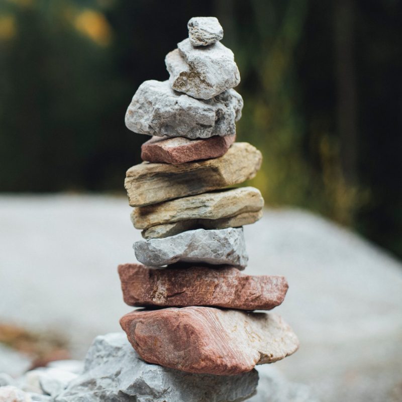 image depicts a stack of stones all balanced getting smaller from the base upwards