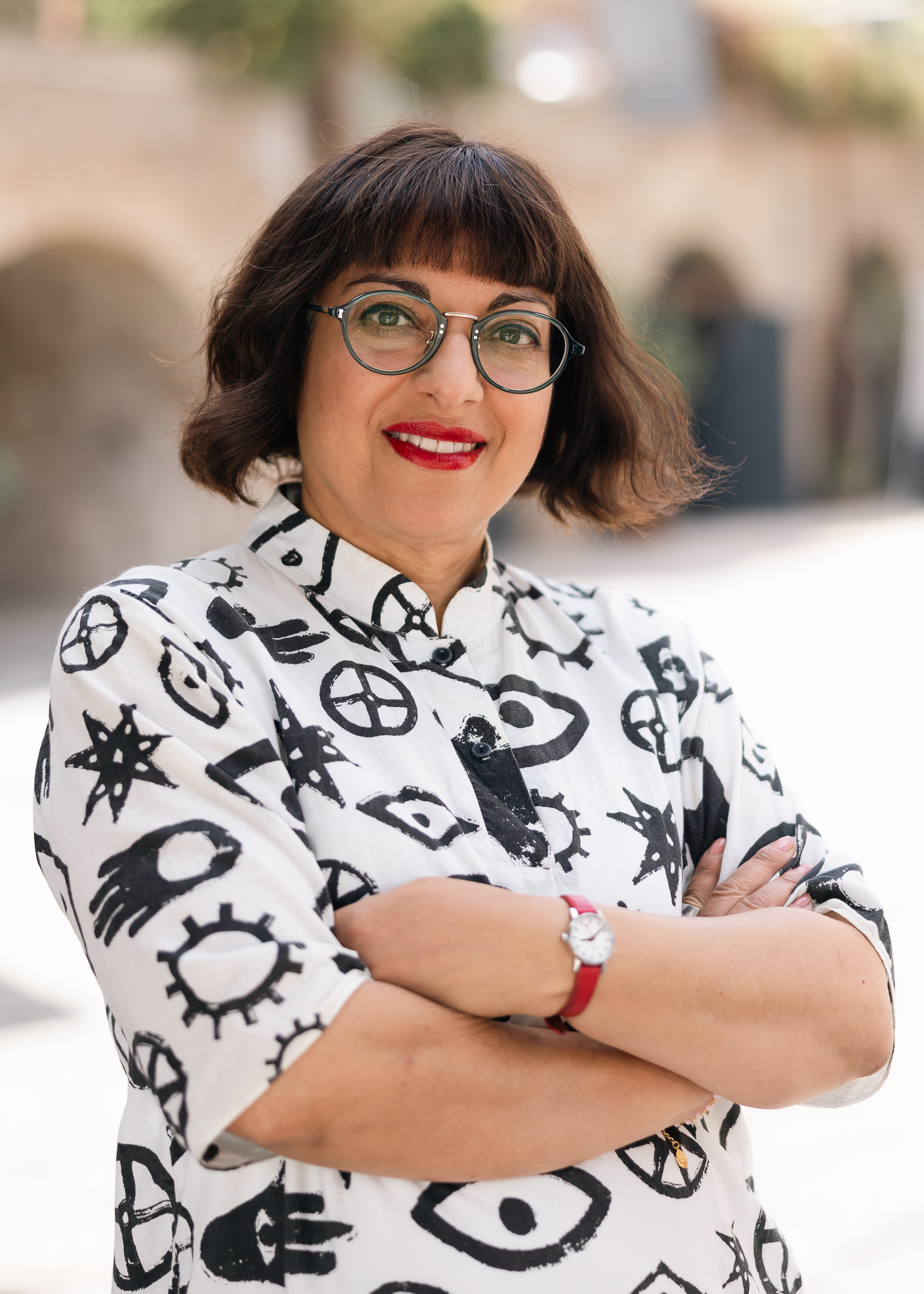 Binita Walia an indian women with bobbed brown hair and glasses stands smiling